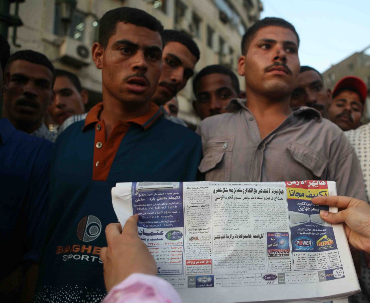 A demonstrator holding Al-Ahram newspaper issue in front of the security-deployed thugs (Photo by Amr Abdallah, 26 July 2006)