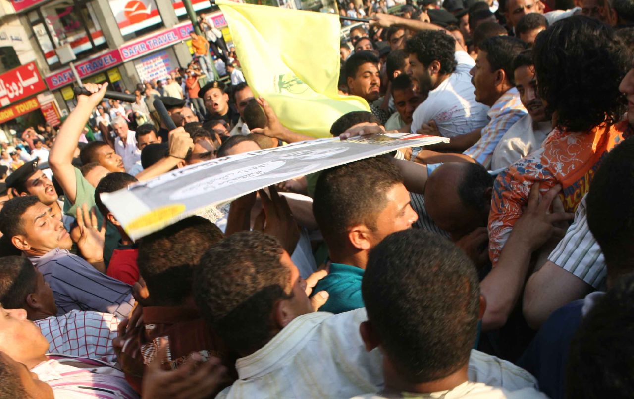 Thugs, deployed by the Egyptian police in Tahrir Square, attack protesters with batons (Photo by Amr Abdallah, 26 July 2006)
