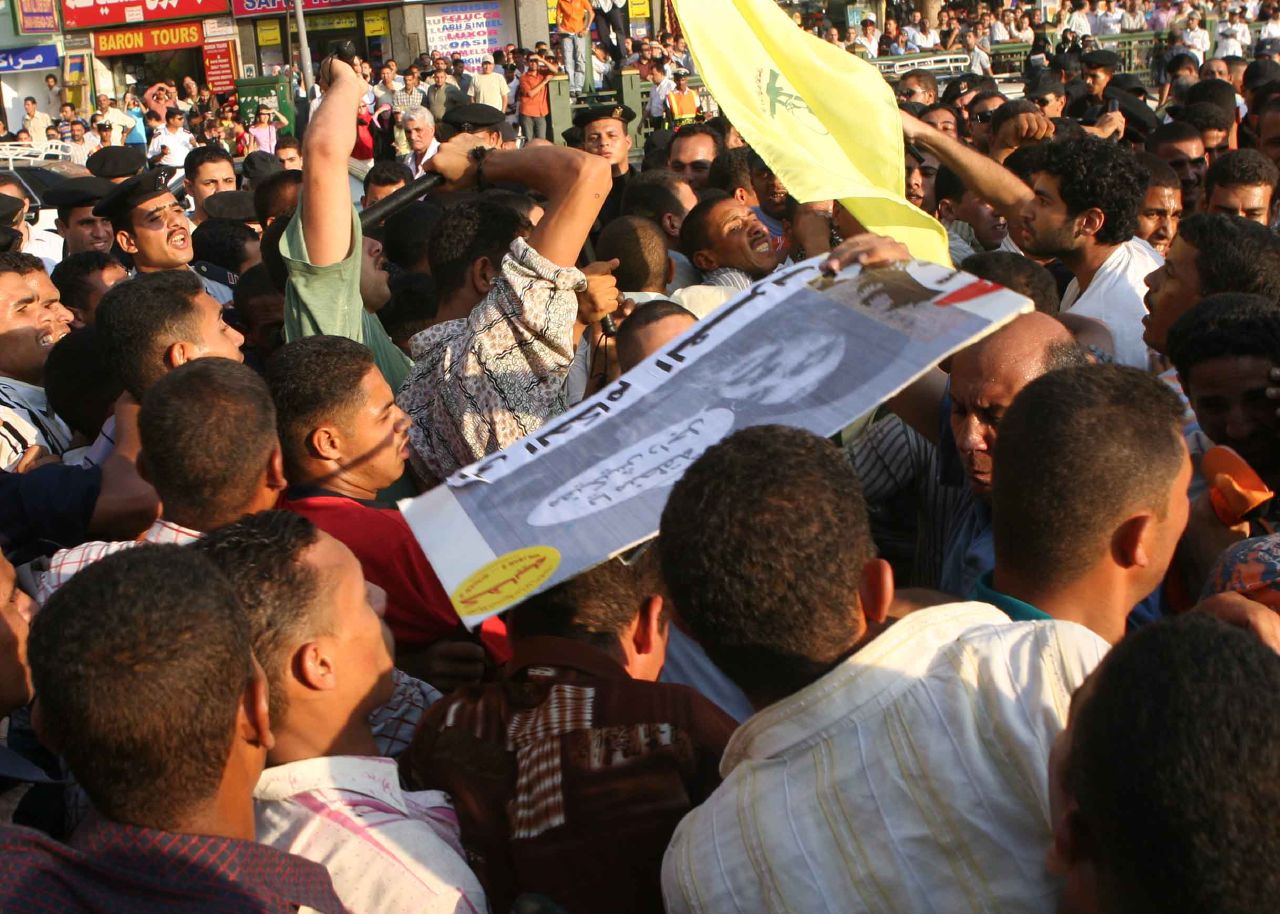 Thugs, deployed by the Egyptian police in Tahrir Square, attack protesters with batons (Photo by Amr Abdallah, 26 July 2006)