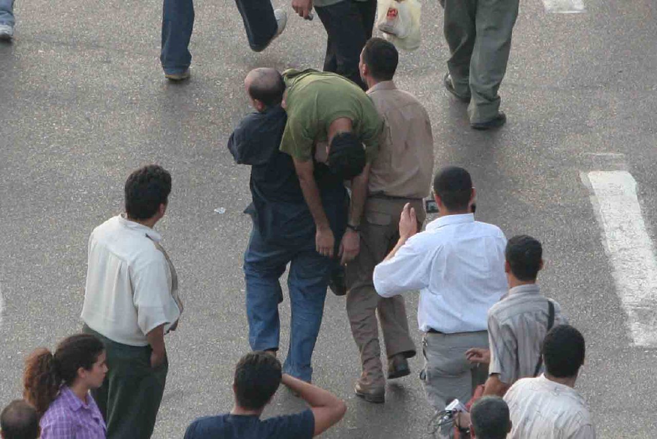 An activist who refused police orders to leave was forcefully carried away by plainclothes security agents (Photo by Nasser Nouri, 26 July 2006)